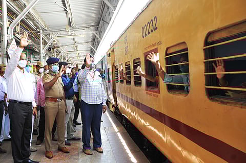 Stranded persons wave hands as the fourth Shramik special chugging off Katpadi railway junction in Vellore district. (Photo | Express)