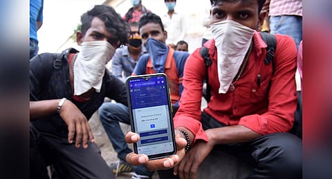 A migrant worker shows the Railway website on his mobile phone which didn’t facilitate ticket booking to travel to his native place. (R Satish Babu, EPS)