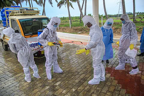Municipal workers wearing protective gear disinfect after cremating the body a man who died due to COVID-19 at a crematorium in Kanyakumari Monday May 11 2020. (Photo | PTI)