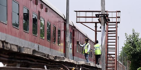 A worker seen engaged in cleaning the railway coaches at the yard in New Delhi Railway station. (Photo | Parveen Negi, EPS)
