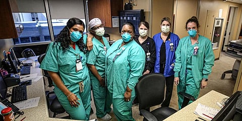 Nurses on duty at the coronavirus isolation ward pose for a photo at their station. (Photo | AP)