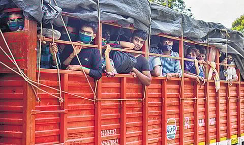 Migrants board a truck as they leave for their native villages in Prayagraj | pti