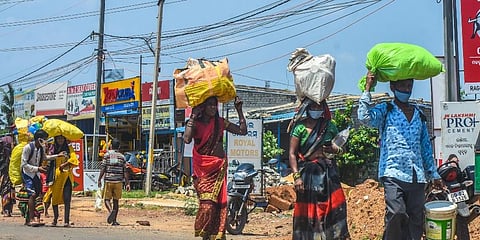 Migrant workers from Jagatsingpur on the way to their hometown Chhatisgarh seen crossing NH-16 in Bhubaneswar.(Photo | Biswanath Swain, EPS)