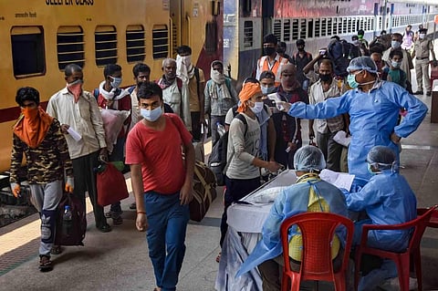 Healthcare workers screening migrant workers before letting them board the Shramik Special train. (Photo | PTI)