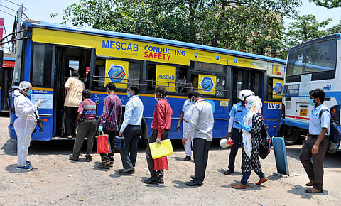 A state government bus conductor wearing a protective suit counts passengers boarding in a bus after authorities eased restrictions during the ongoing COVID 19 nationwide lockdown at Garia terminus in Kolkata Friday May 15 2020. (Photo | PTI)