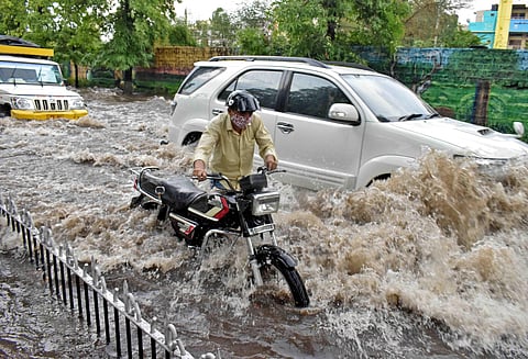 Motorists ride their vehicles through the water-logged Raj Bhavan Road in Hyderabad. (Photo | S Senbagapandiyan, EPS)