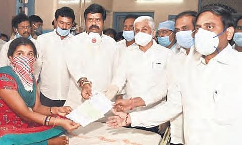 Ministers K Kannababu and M Srinivasa Rao, and MP Vijayasai Reddy hand over cheques to those discharged from KGH in Vizag on Wednesday (Photo | EPS)