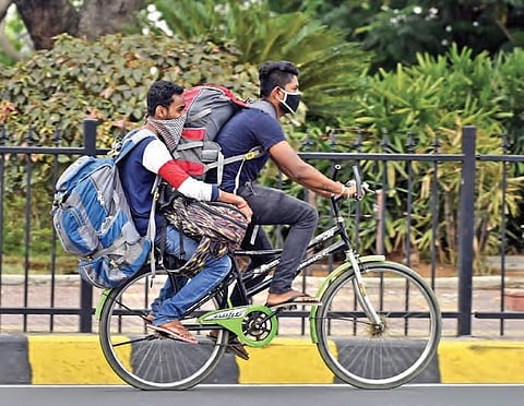 Two migrants, who are eager to reach their native place, leave Hyderabad on a bicycle carrying heavy luggage. (Photo | Vinay Madapu, EPS)