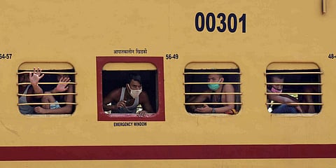 Migrant workers see outside the train window as they travel in a special train to arrive in their native places during a government-imposed nationwide lockdown as a preventive measure against coronavirus, in Prayagraj on Monday. (Photo| ANI)
