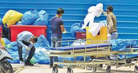 Health workers dispose of medical waste in open at a government hospital in New Delhi | file