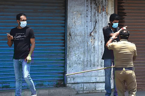 Police chase migrant workers who gathered at Rippon building to get their travel passes. (Photo |EPS/ Ashwin prasath)