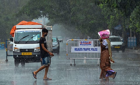 People walk in the rain due to weather changes ahead of landfall by cyclone 'Amphan' in Kolkata Tuesday May 19 2020. (Photo | PTI)