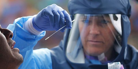 Salt Lake County Health Department public health nurse Lee Cherie Booth performs a coronavirus test outside the Salt Lake County Health Department, Wednesday, May 20, 2020, in Salt Lake City. (Photo | AP)
