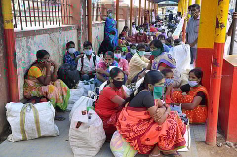 Migrants sit in front of KSRTC bus stand due to lack of money to take a private vehicle after the authorities cancelled the buses for Tamil Nadu during the ongoing COVID-19 lockdown in Chikmagalur Friday May 22 2020. (Photo | PTI)