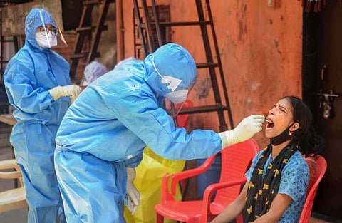 A healthcare worker collecting swab sample from a woman in Mumbai. (Photo | PTI)