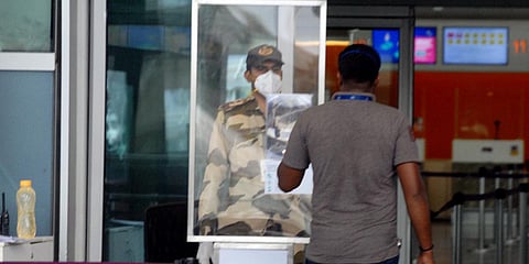 A security man checks the ID of staff before entering the Kempe Gowda International Airport in Bengaluru on Sunday. (File photo| ANI)
