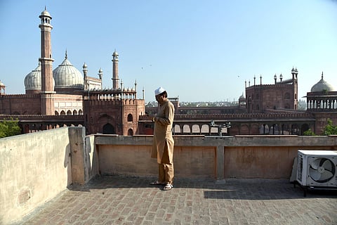 A man offers Namaz on Eid on a rooftop in front of Jama Masjid in Delhi. (Photo| ANI)
