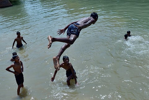 A boy takes a dip in a canal to beat the heat. (Photo| PTI)