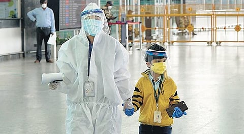 A five-year-old boy, son of a Bengaluru couple, arrives at KIA, escorted by an airport staffer in PPE. “He went to his grandparents’ house in Delhi and got stuck there for three months. We wanted to bring him home and so he was made to travel on his own,”