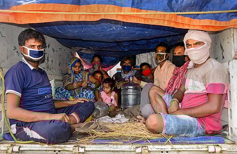 Migrants travel in a truck to reach their destination during the ongoing COVID-19 nationwide lockdown in Patna Wednesday. (Photo | PTI)