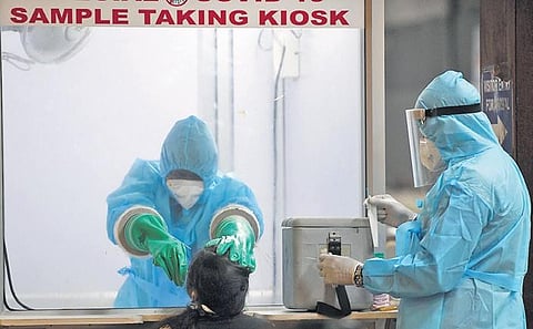 A file picture of medical staff collecting swab samples at Chennai International Airport from an Indian citizen who returned from Dubai