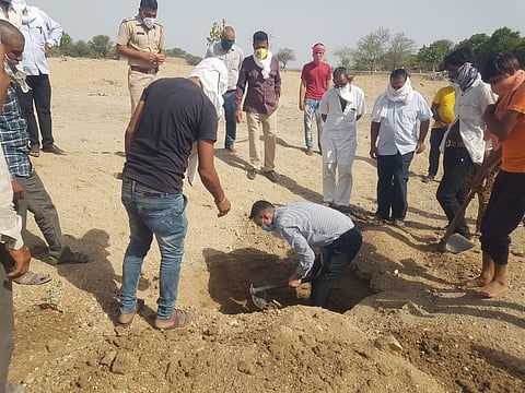 Mandal Subdivision Magistrate Mahipal Singh digging the pit for the burial (Photo | Sanjay Ladda)