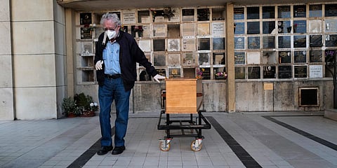 A man pays respects near the coffin of his wife who was 75-years-old, during a funeral ceremony under the care of Paris undertaker Franck Vasseur, at Pere Lachaise cemetery in Paris. (File photo| AP)