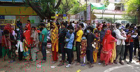 Migrant workers and their families wait to get on a bus to reach a railway station to board a train to their home state during an extended lockdown to slow the spreading of the coronavirus disease COVID-19 in New Delhi on Friday. (Photo | Shekhar Yadav/EP