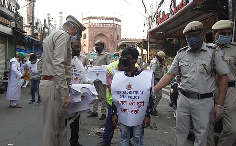 Delhi police distributes a paper kit to make awareness about social distancing near Jama Masjid area to control the spread of coronavirus during the fourth phase of nationwide lockdown in Delhi on Wednesday. (Photo | Anil Shakya/EPS)