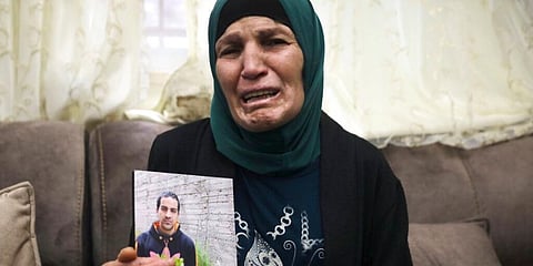 Rana, mother of Iyad Halak, holds his photo at their home in East Jerusalem. (Photo | AP)