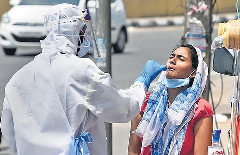 Health workers collect swab samples at a mobile Covid-19 testing van at Filmistan area in north Delhi | Parveen Negi