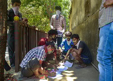 Migrants fill up forms outside a police station as part of necessary formalities to travel back to their native places amid COVID-19 lockdown in Thane Monday May 4 2020. (Photo | PTI)