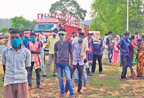 The labourers who returned in trucks from Telangana, wait at Kalahandi border on NH-26 for administrative approval to enter the district I Express