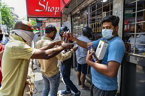 People purchase alcohol from a wine shop after authorities allowed sale of liquor with certain restrictions during the ongoing COVID-19 nationwide lockdown in Lucknow Monday May 4 2020. (Photo | PTI)