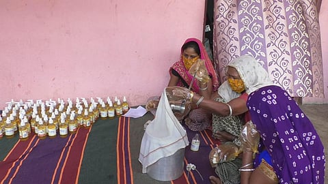 Tribal women packing mahua-based hand sanitizer (Photo | EPS)