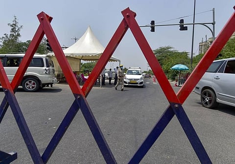 Cops check authority passes of commuters at a state border during the ongoing COVID-19 lockdown. (Photo | PTI)