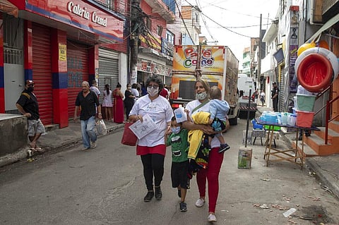 Residents of Paraisopolis slum walk home after attending a health workshop on how to stay safe amid the new coronavirus pandemic in Sao Paulo, Brazil, Wednesday, May 6, 2020. (Photo | AP)