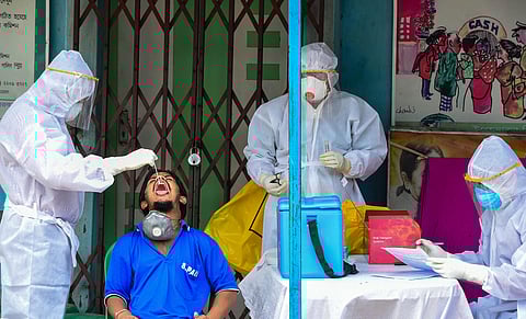 Health workers collect swab sample from a person for COVID-19 test, during ongoing COVID-19 lockdown, in Kolkata. (Photo | PTI)