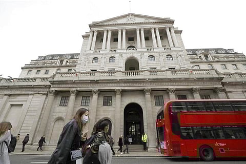 Pedestrians wearing face masks pass the Bank of England in London. (Photo | AP)