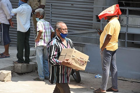 People carrying cases of liquor on day 2 after shops were opened during lockdown in Hyderabad on Thursday. (Photo | EPS/RVK Rao)
