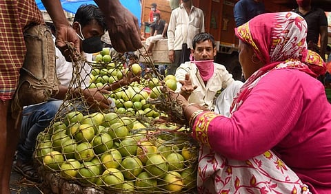Workers sort fruits at a wholesale market during the ongoing nationwide COVID-19 lockdown. (Photo | PTI)