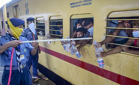 Cadets of Scouts and Guides refill water bottles of migrants sitting in Shramik Special train to reach their native places during ongoing COVID-19 lockdown at Prayagraj Railway Station Sunday May 31 2020. (Photo | PTI)