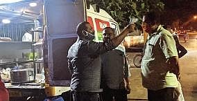 An employee of Irani Food truck checking the temperature of a customer ,Express