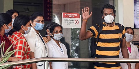 Taxi driver Latheesh waves as he leaves after being discharged from a hospital following his recovery from COVID-19. (Photo | PTI)