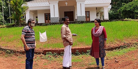 Rani and Tomy Puthupally with assistant agriculture officer Rajesh K (left) in front of their paddy field at Ariyuruthi in East Eleri Panchayat. (Photo| EPS)