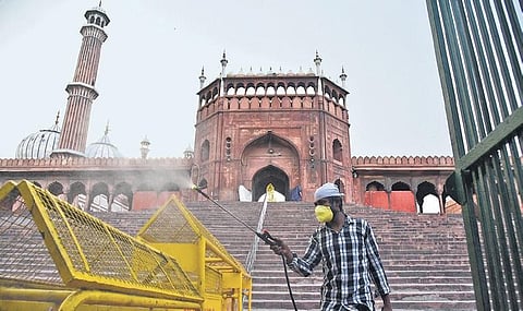 A volunteer uses disinfectant to sanitise the Jama Masjid premises. (Photo | Parveen Negi, EPS)
