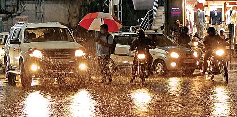 Commuters try to wade through sheets of water after showers lash the city on Wednesday | VINAY MADAPU