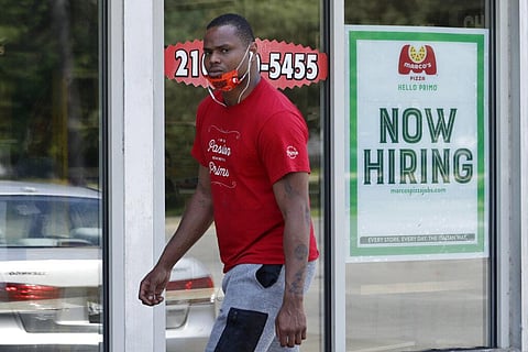 A man walks past Marco's Pizza, which is now hiring, Friday, June 5, 2020, in Euclid, Ohio. U.S. unemployment dropped unexpectedly in May to 13.3% as reopened businesses began recalling millions of workers faster than economists had predicted, triggering 