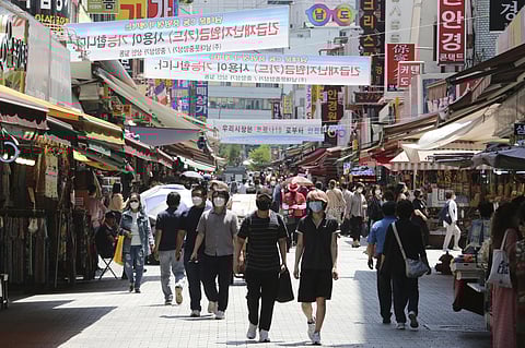 People walk on a shopping district in Seoul, South Korea. (Photo | AP)