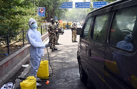 Workers clad in PPE disinfecting vehicles. Image used for representational purpose.(Photo |Parveen Negi, EPS)